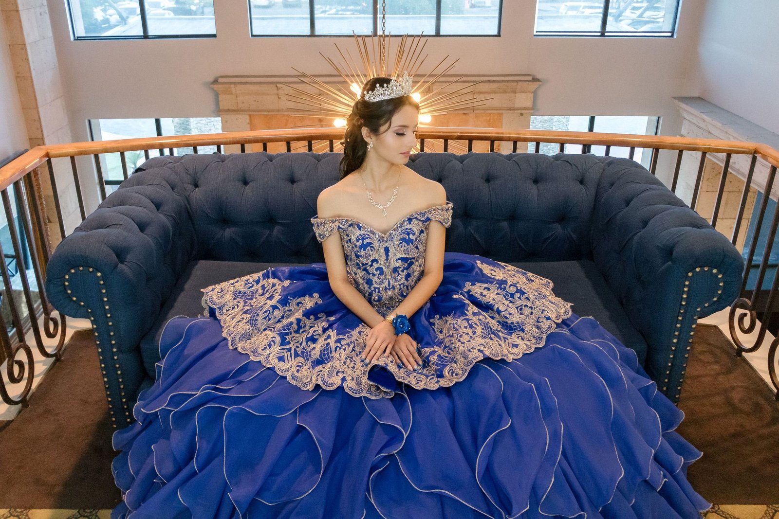 Retrato de quinceañera con vestido azul sentada