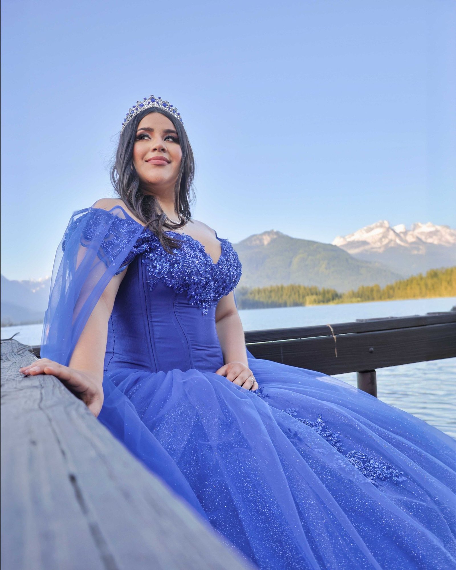 Retrato de quinceañera con vestido azul junto al lago