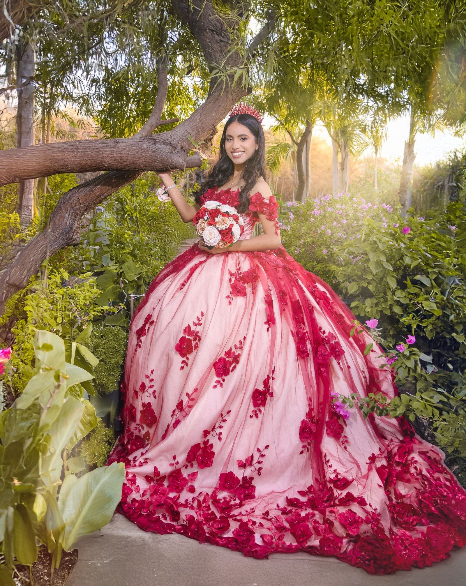 Quinceañera con vestido rojo y rosa en exterior