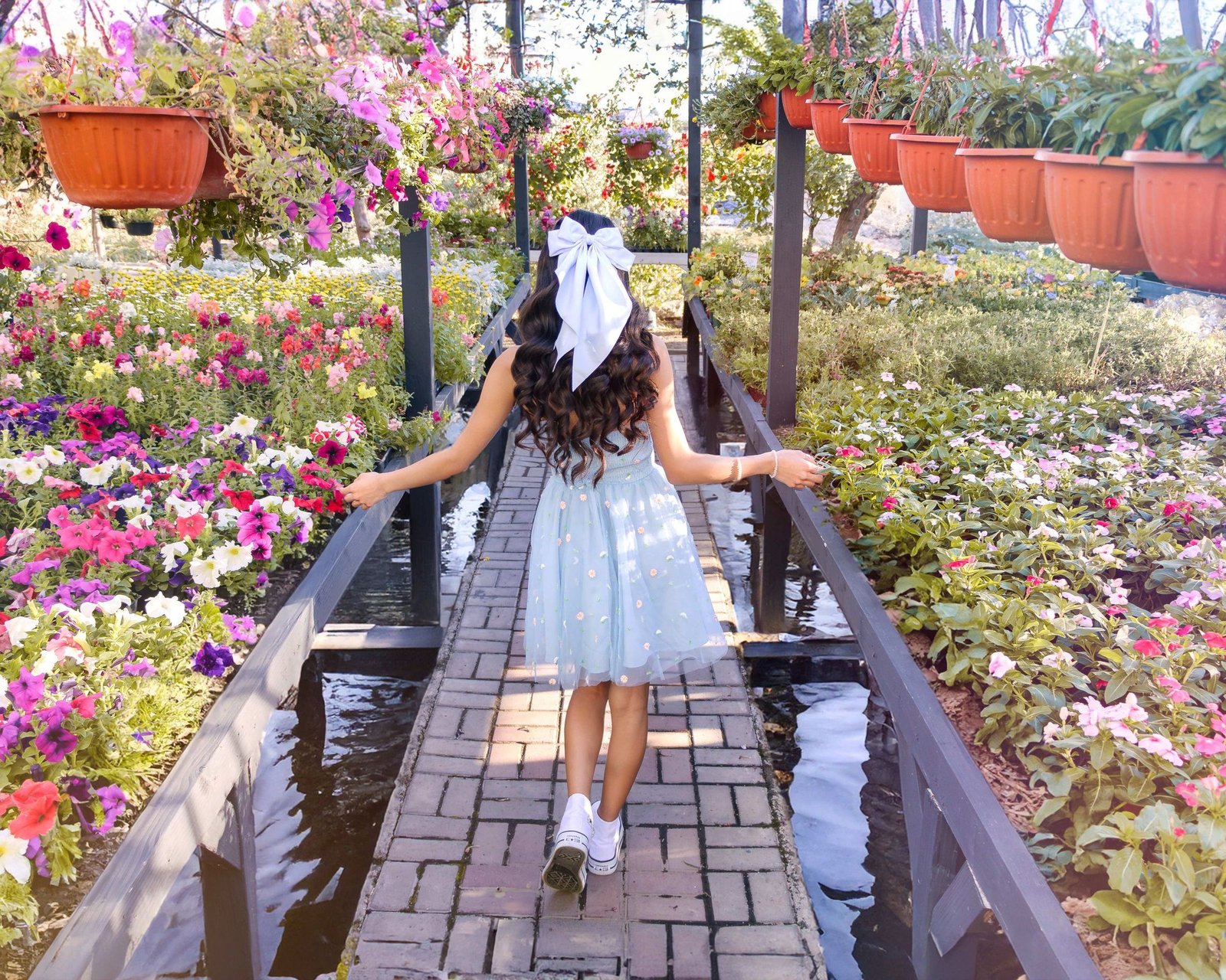Quinceañera en un puente rodeado de flores